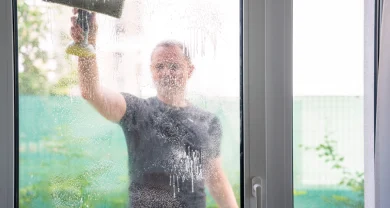 Mann putzt Fenster